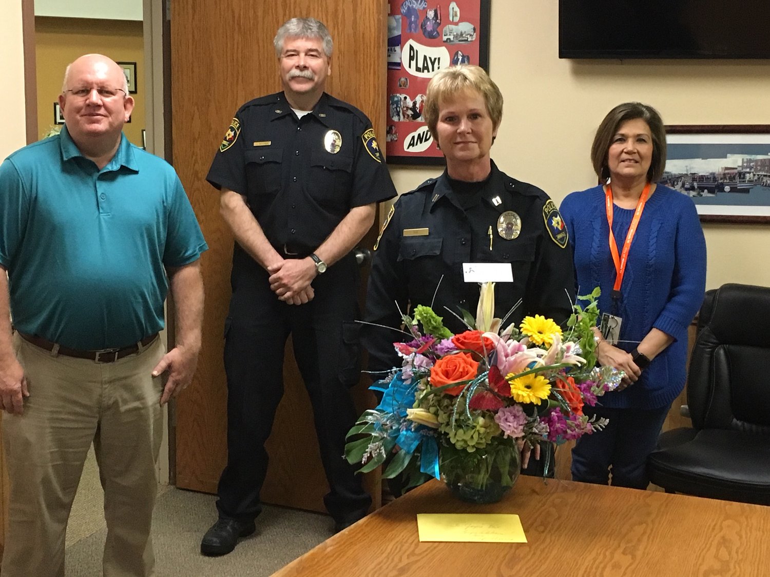 The retirement party of Mineola Police Capt. Joyce Box last week had to be scaled back. From left are Mayor Kevin White, Police Chief Chuck Bittner, Box and City Manager Mercy Rushing.
